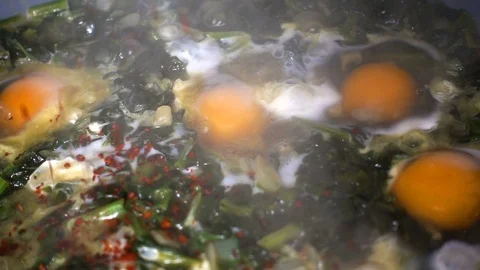 Adding Red peperoni  on Cooking Spinach  Stock Footage 104892847