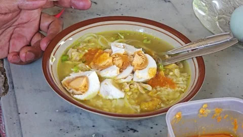 Adding Red Sambal Chili Paste To Indonesian Soto Ayam Chicken Soup Stock Footage 340046454