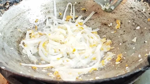 Adding rice noodles to stir-fry Pad Thai in a hot wok. Stock Footage 342402610