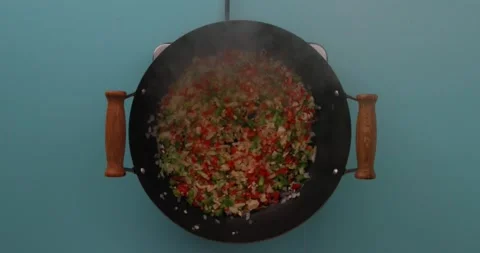 Adding rice to vegetable mixture Stock Footage 132198778