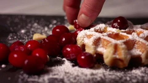 Adding ripe cranberries to waffles with sugar dusting Stock Footage 331246972