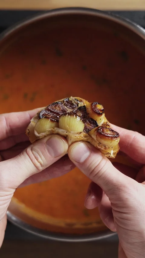 Adding Roasted Garlic to Tomato Soup Top View Close Up Vídeo Stock 332358666