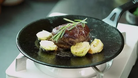 Adding Rosemary on Cooked Steak in Pan Stock Footage 334358113