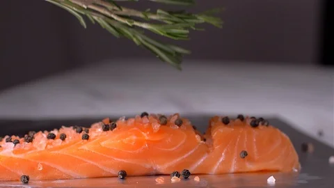 Adding rosemary to fish salmon. Slow motion Stock-Footage 105131063