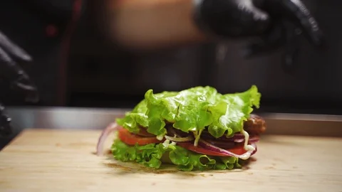 Adding a Salad Leaf to a Burger Stock Footage 129685102