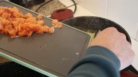 Adding salmon pieces to sauce for salmon lasagna. Home cooking close up Stock Footage 233274404