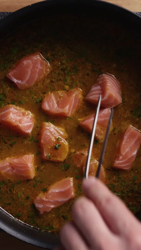 Adding Salmon to Tomato Sauce Close Up Видео 329889808