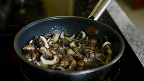 Adding Salt and Garlic to Simmering Mushrooms Stock-Footage 315242179