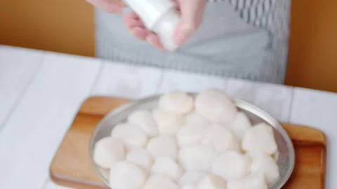 Adding salt and pepper into a bunch of raw scallops in 4K. Stock Footage 138059221