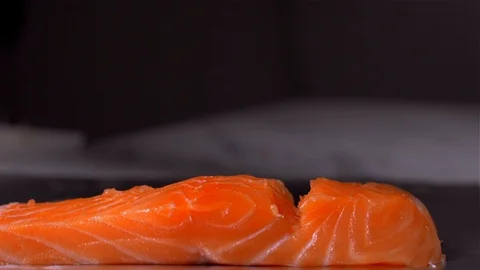 Adding salt and pepper to fish salmon. Slow motion Stock Footage 105131795