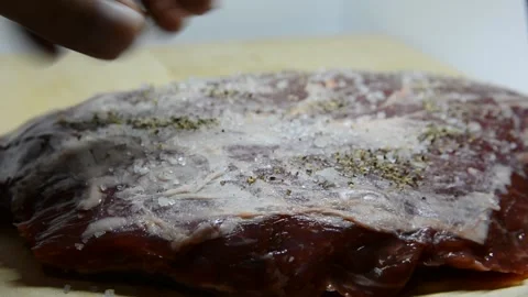 Adding salt and seasoning to beef.salt and pepper a peace of fresh meat Video stock 139980863