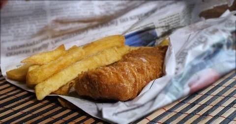 Adding salt and vinegar on an English fish and chips Stock Footage 75278131