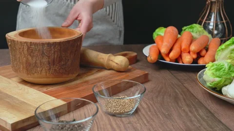 Adding Salt, Black Pepper, Coriander Seeds into a pestle and mortar for grinding Stock Footage 145104398