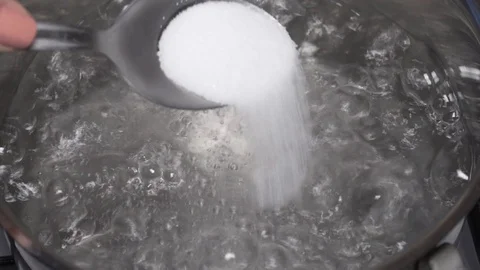 Adding salt to boiling water in the pan Stock Footage 100670112