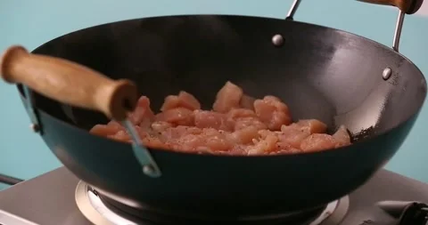 Adding salt to chicken cooking in a skillet Stock Footage 132198673