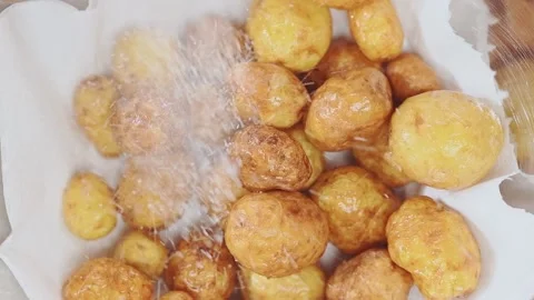 Adding salt on fried small new potatoes. Stock Footage 153481060