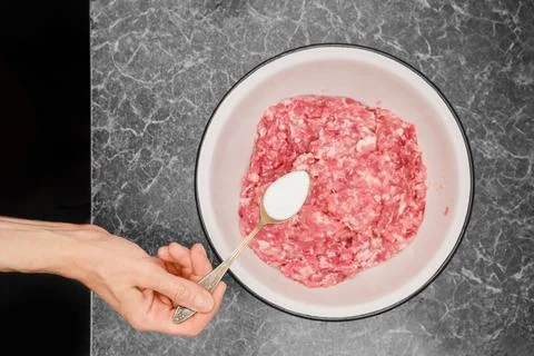 Adding salt to minced meat Stock Photos