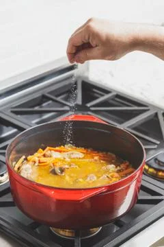 Adding salt to Pilaf being cooked at home Stock Photos
