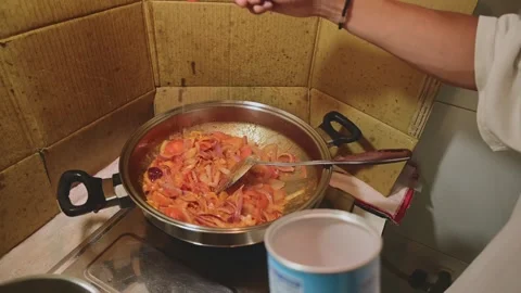 Adding Salt to Tomato and Onion Sauce in Stainless Steel Pan During Cooking Stock Footage 340955515