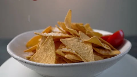 Adding salt on Tortilla chips rotating Stock Footage 154269376
