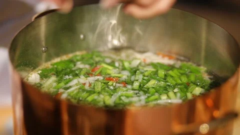 Adding salt to the vegetable soup. soup from mussels, The process of cooking Stock Footage 90465200