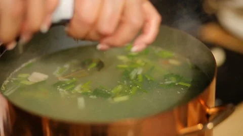 Adding salt to the vegetable soup. soup from mussels, The process of cooking Stock Footage 90465587