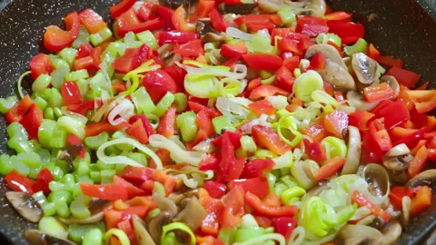Adding salt to vegetables that are being fried in a pan Slow motion video 100fps Stock Footage 309300275