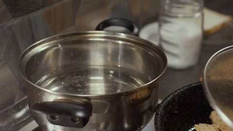 Adding salt in water in pan Stock Footage 126472231