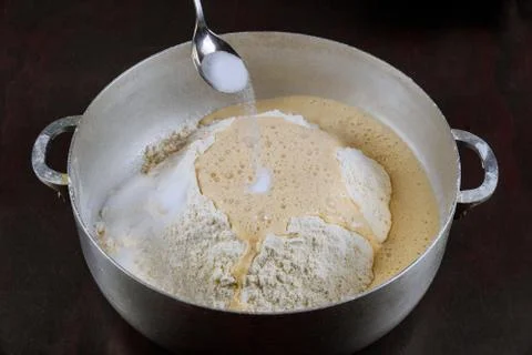 Adding salt to yeast dough for making bread. Stock Photos