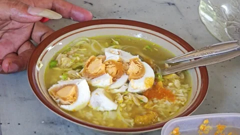 Adding Sambal Chili Paste To Indonesian Chicken Soup Soto Ayam With Salted Egg Stock Footage 340046416