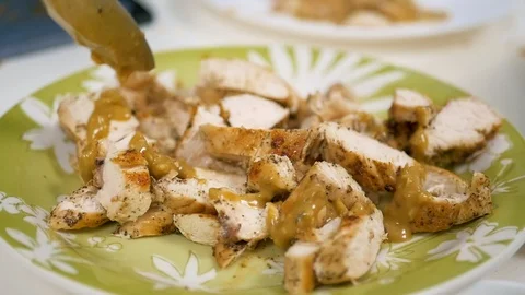 Adding sauce over the fried chicken breast pieces Stockbeeldmateriaal 124961261