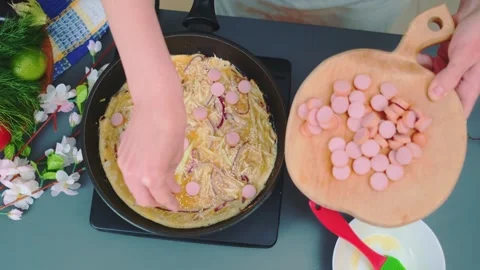 Adding sausage to cabbage casserole in a pan Видео 249079178