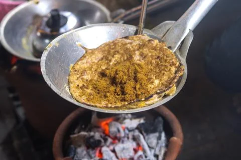 Adding Serundeng Spiced Coconut Topping onto Freshly Cooked Kerak Telor Ome.. 스톡 사진
