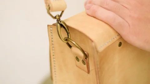 Adding a shoulder strap to a leather bag Video stock 126074036