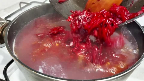 Adding Shredded Beets to Simmering Broth with Steam Rising Stock-Footage 321049198