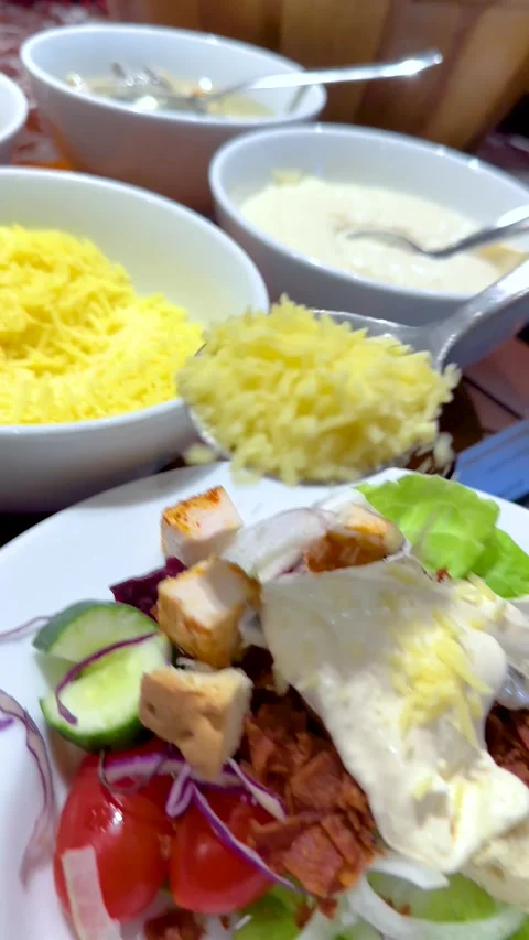 Adding Shredded Cheese to a Fresh Caesar Salad with Creamy Dressing Stock Footage 335620641