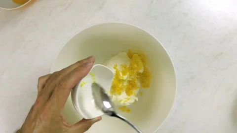 Adding shredded lemon rind into bowl with cream cheese. Stock Footage 100232136