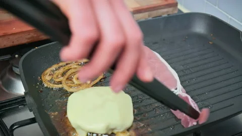 Adding a slice of bacon into a grilling pan in 4K. Stock Footage 153745170