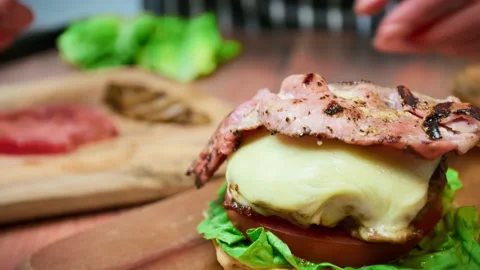 Adding a slice of grilled bacon on a burger in 4K. Stock Footage 153748375