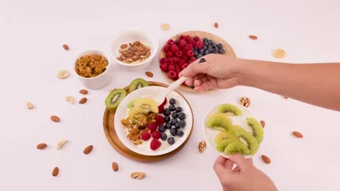 Adding Sliced Kiwi to a Healthy Greek Yogurt Fruit Bowl Stock Footage 337767948