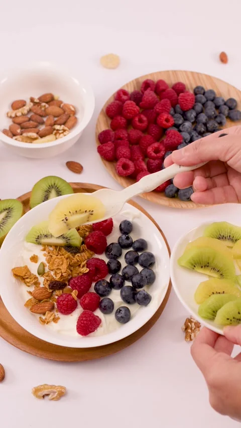Adding Sliced Kiwi to a Healthy Greek Yogurt Breakfast Bowl Stock Footage 337860347