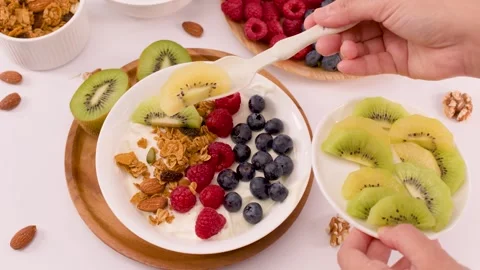 Adding Sliced Kiwi to a Healthy Greek Yogurt Fruit Bowl Stock Footage 338052701