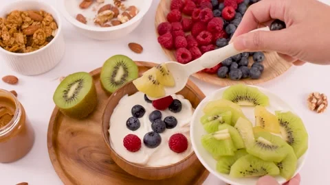 Adding Sliced Kiwi to a Healthy Yogurt Breakfast Bowl Stock Footage 337689723