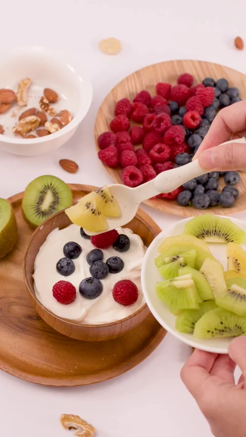 Adding Sliced Kiwi to a Healthy Yogurt Breakfast Bowl Stock Footage 337876762