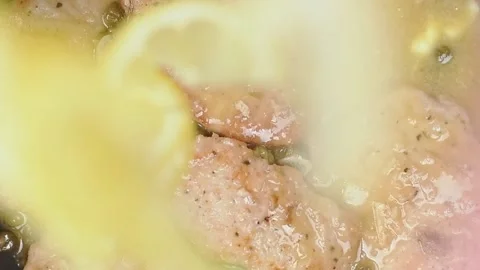 Adding sliced lemon on a tasty pork Scallopini with capers. Stock Footage 153481852