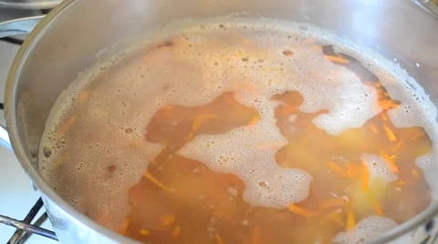 Adding sliced onion into saucepan with boiling buckwheat soup Stock-Footage 67309507