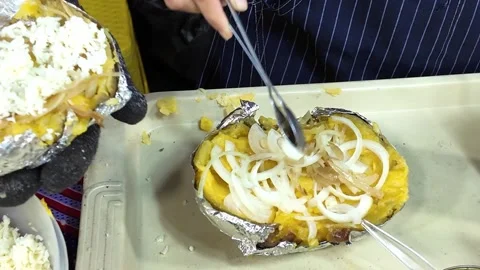 Adding Sliced Onion to Stuffed Baked Potato at Street Food Market Stock Footage 337421270
