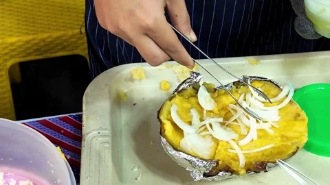 Adding Sliced Onion to a Stuffed Baked Potato at Street Food Stall Video stock 337421276