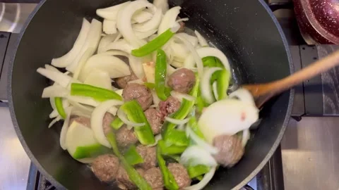 Adding Sliced Onions and Green Peppers to Meatballs in a Pot Video stock 346272877