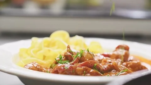 Adding sliced parsley on a chicken paprikash, served on a plate. Stock Footage 159402230